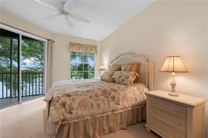 Bedroom with multiple windows, light colored carpet, access to outside, and ceiling fan
