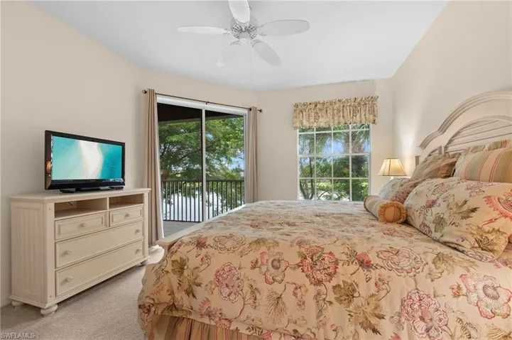 Carpeted bedroom with access to exterior and ceiling fan