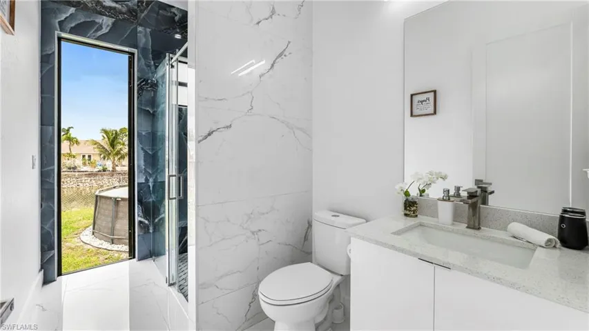 Bathroom with vanity and a marble finish shower