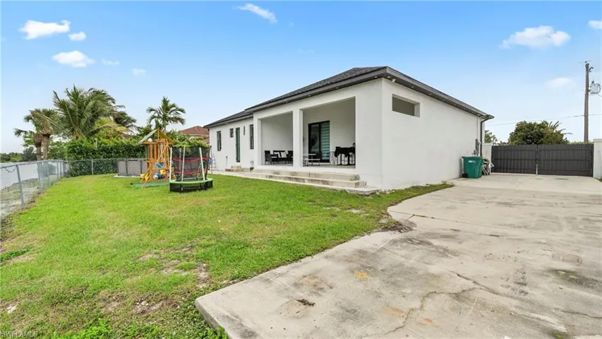 Back of property with a fenced backyard, a playground, stucco siding, a patio, and a trampoline