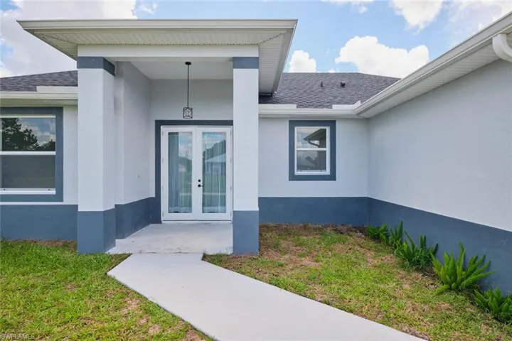 Doorway to property with french doors, roof with shingles, and stucco siding