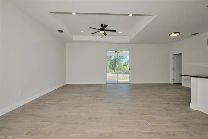 Spare room with a raised ceiling and ceiling fan
