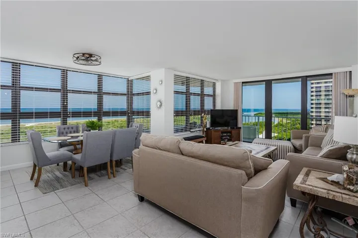 Living room featuring a wall of windows, radiator heating unit, and light tile patterned floors