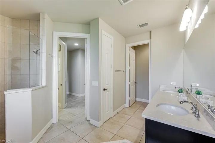 Master bathroom featuring double vanities, walk-in shower and water closet
