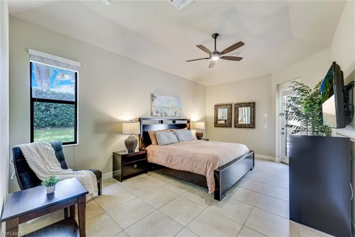 Large master bedroom with king bed, reading nook by the window, and private access to the lanai and pool