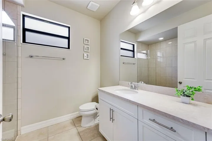 Guest bathroom with walk-in shower, white cabinets, and plenty of counter space