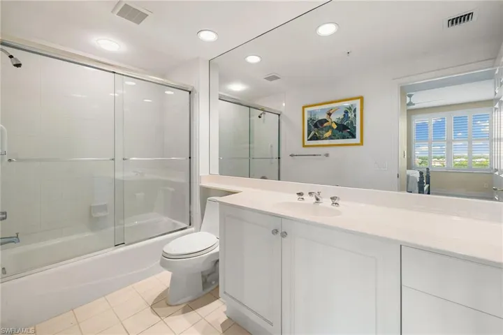 Bathroom featuring combined bath / shower with glass door, light tile patterned floors, vanity, and recessed lighting