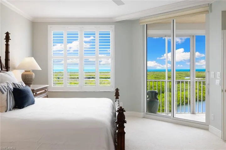 Carpeted bedroom with multiple windows, access to exterior, a water view, crown molding, and ceiling fan