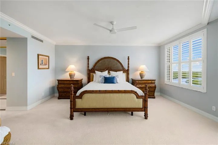 Carpeted bedroom with crown molding and a ceiling fan