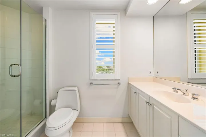 Full bath featuring vanity, light tile patterned flooring, a stall shower, and recessed lighting