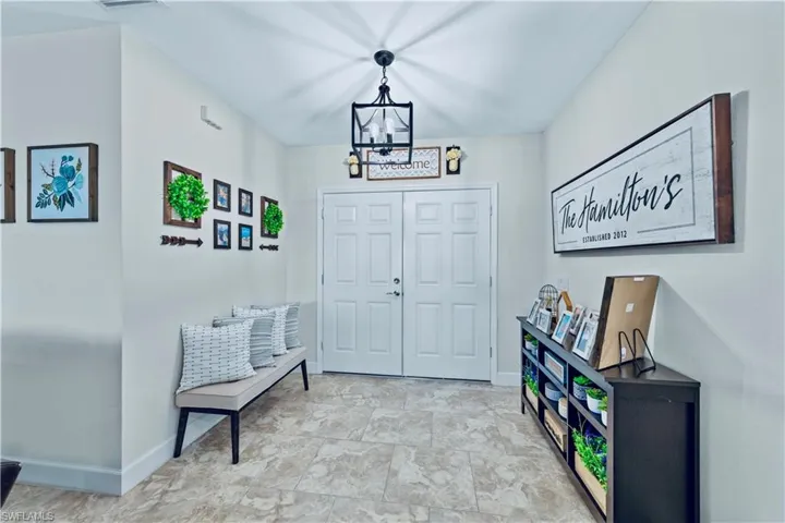 Foyer with baseboards and an inviting chandelier