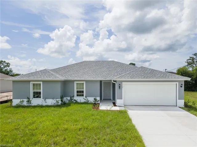 Single story home featuring stucco siding, a shingled roof, an attached garage, driveway, and a front yard