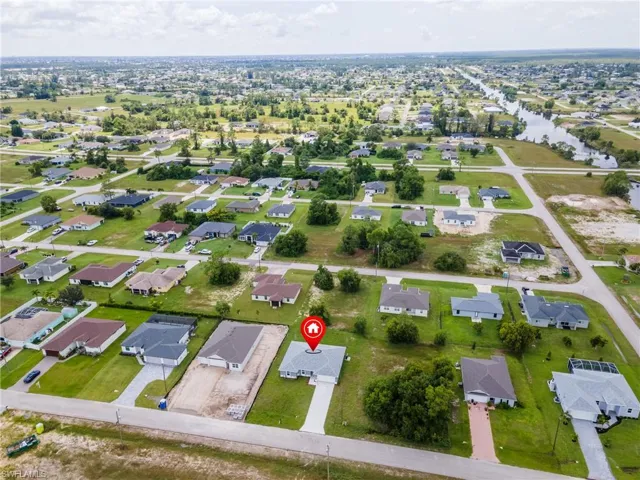 Aerial view of property and surrounding area featuring a large body of water and nearby suburban area