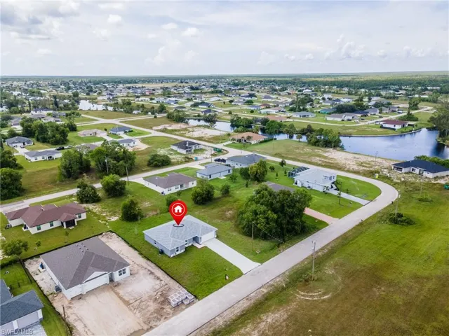 Aerial view of property and surrounding area with nearby suburban area and a large body of water