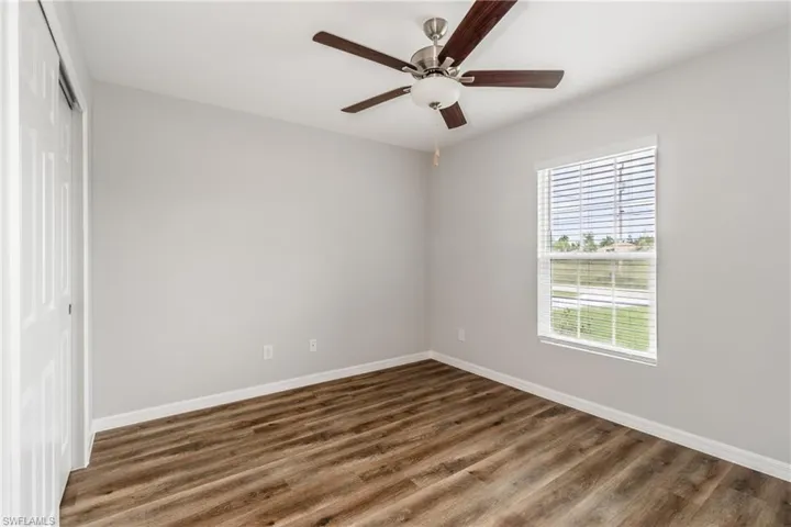 Unfurnished bedroom with a closet, wood finished floors, and ceiling fan