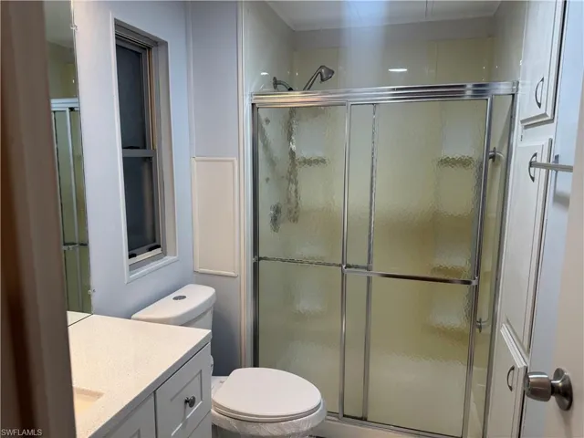 Shower stall with sliding frosted glass doors and chrome hardware
