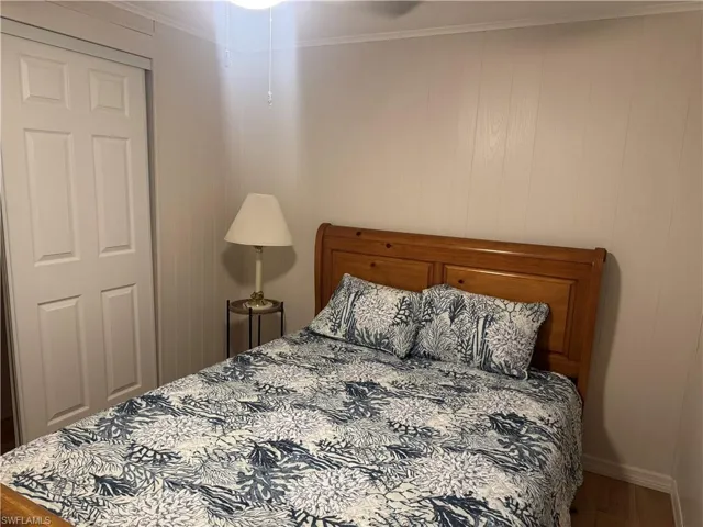 Wood-finish flooring and white paneling define this room, featuring a built-in closet with bi-fold doors