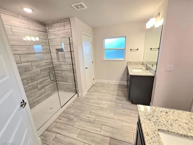 Bathroom featuring vanity and an enclosed shower