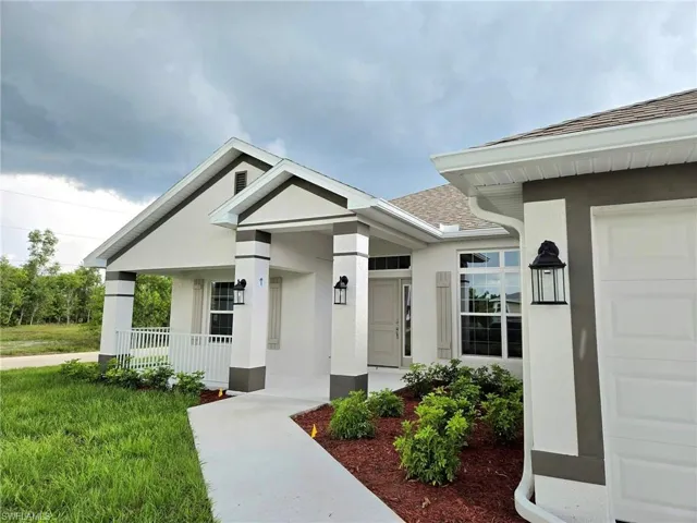 View of front of house featuring a garage, a front lawn, and a porch