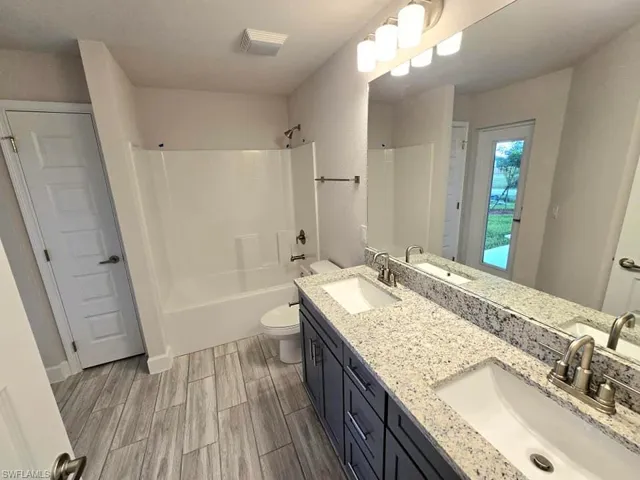 Full bathroom with toilet, vanity, and shower / bathtub combination