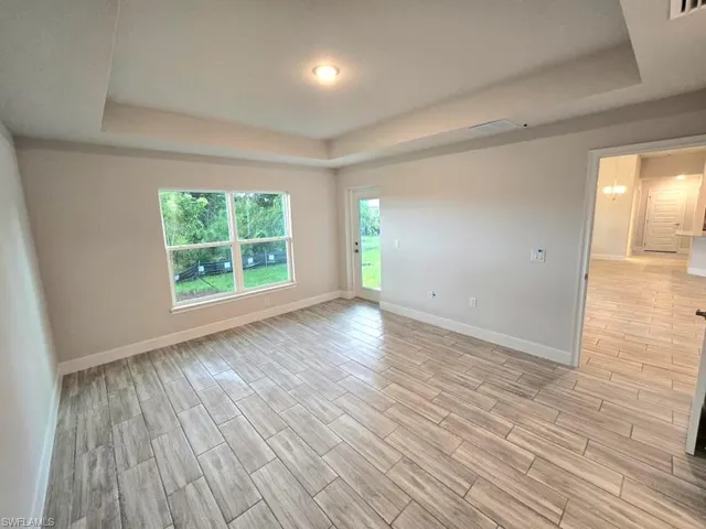 Empty room featuring light hardwood / wood-style floors and a tray ceiling