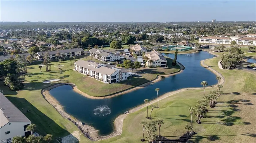 Aerial view of property and surrounding area with a large body of water, nearby suburban area, and a golf course