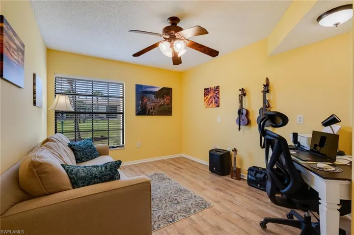 Office space featuring light wood finished floors, a textured ceiling, and a ceiling fan