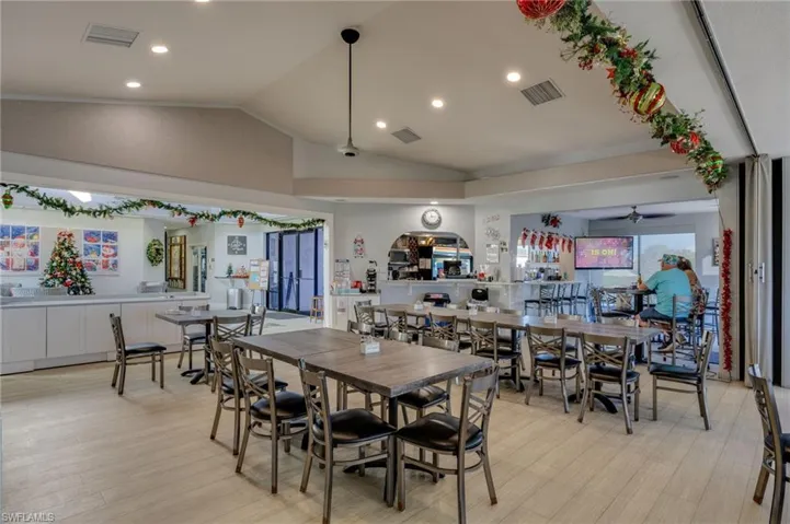 Dining room featuring vaulted ceiling, light wood finished floors, recessed lighting, and ceiling fan
