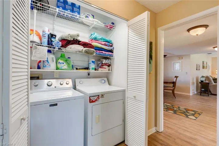 Laundry area featuring light wood finished floors and washer and clothes dryer
