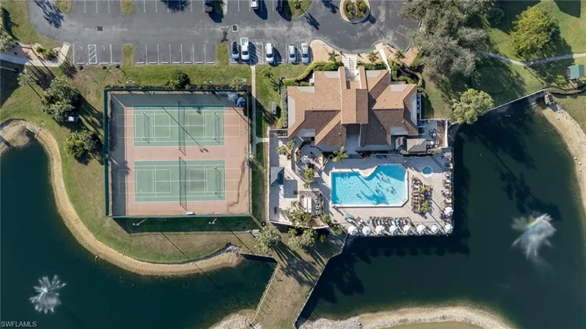Aerial view of property and surrounding area featuring a large body of water and a pool area