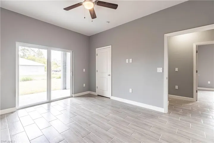 Unfurnished room with ceiling fan, baseboards, and light wood-style flooring