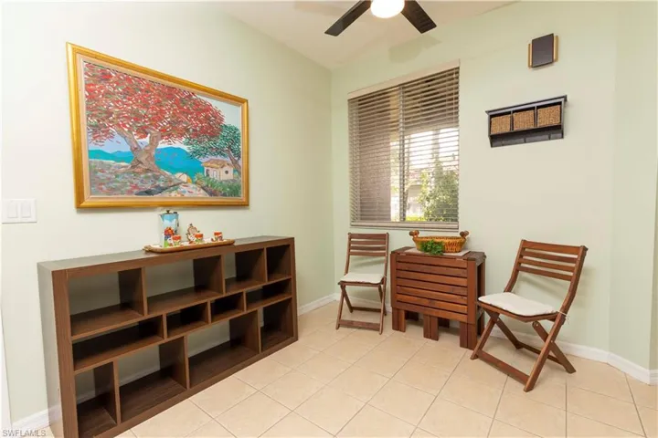 Neutral-toned tile flooring complements light green walls in this versatile room