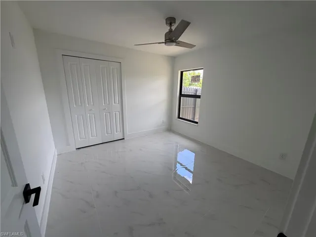 Bright interior space featuring white walls and large format tile flooring