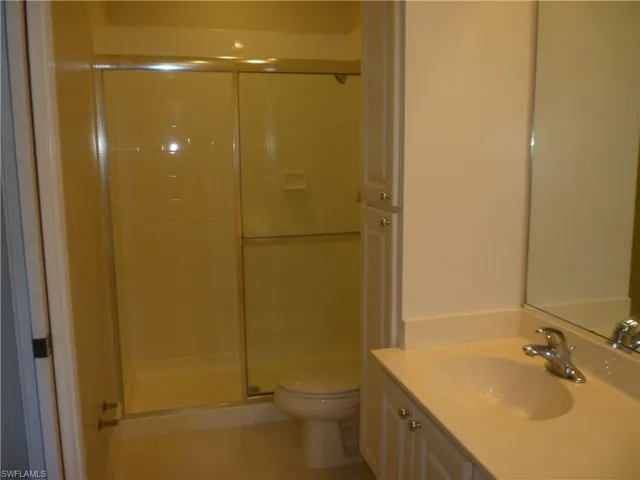 One side of master bathroom with stall shower, and light tile flooring.