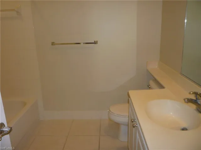 Bathroom featuring lite tile flooring, vanity, and bathtub / shower combination