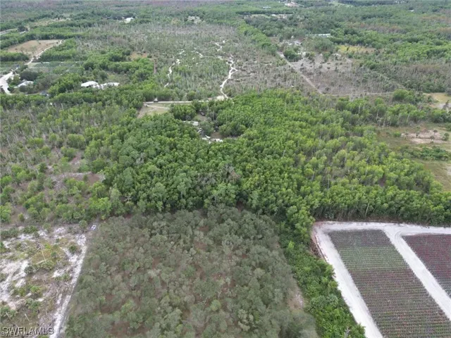 Aerial view of property and surrounding area featuring a heavily wooded area