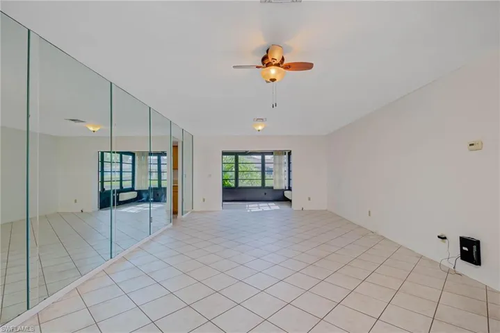 Unfurnished room featuring light tile patterned floors and ceiling fan