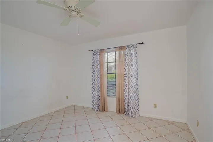 Bedroom with light tile patterned flooring and ceiling fan