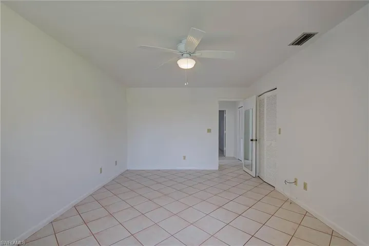 Unfurnished room featuring light tile patterned flooring and a ceiling fan