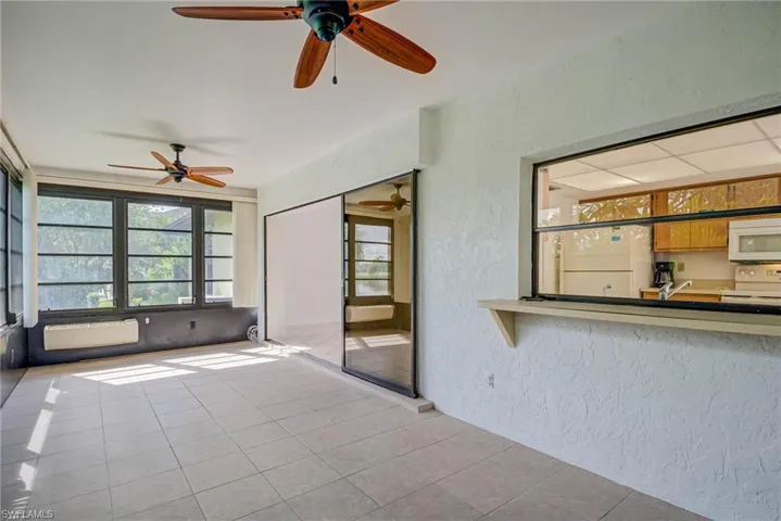Unfurnished sunroom with a textured wall and tile patterned floors
