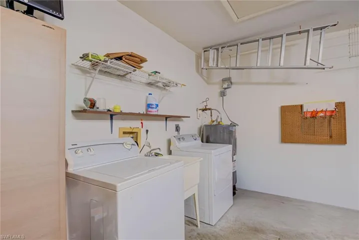 Laundry room featuring separate washer and dryer and water heater