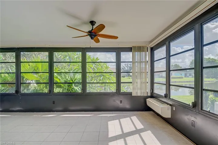 Unfurnished sunroom with an AC wall unit and tile patterned flooring