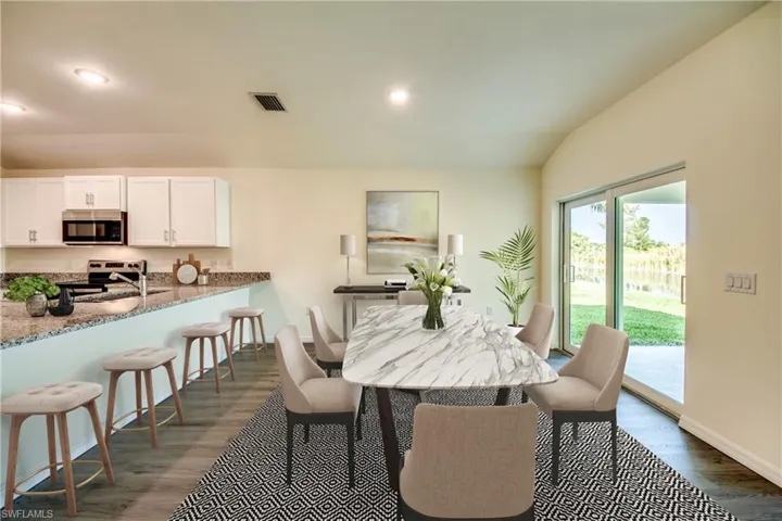 Dining space featuring lofted ceiling, dark wood finished floors, and recessed lighting