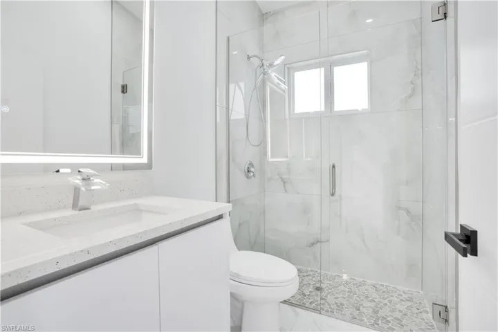 Full bath with a marble finish shower, vanity, and marble finish flooring