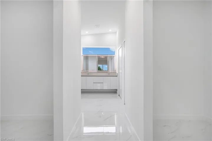 Corridor featuring light marble finish flooring and recessed lighting