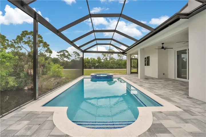 View of pool with a sunroom, a patio area, a pool with connected hot tub, and a lanai