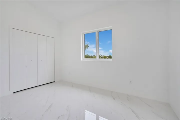 Unfurnished bedroom with light marble finish flooring and a closet