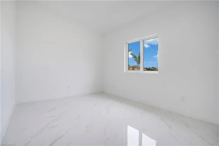 Spare room featuring marble look tile flooring