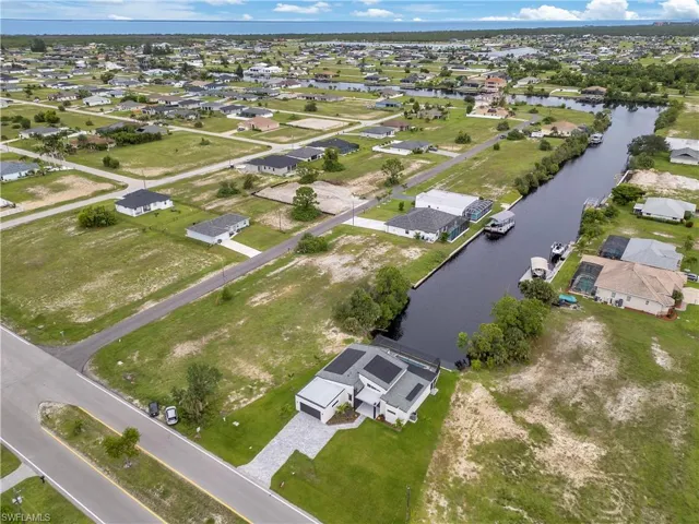 Aerial view of property and surrounding area with nearby suburban area and a nearby body of water
