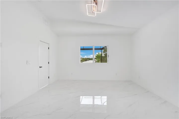 Unfurnished room featuring light marble finish floors and baseboards